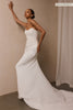 A woman wearing a strapless white wedding gown with a draped bodice and floor-length silhouette_xs_