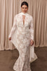 Woman wearing a lace wedding dress with long sleeves and a white shawl