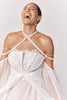 Woman wearing a lace wedding dress with a sheer sleeves laughing_L_