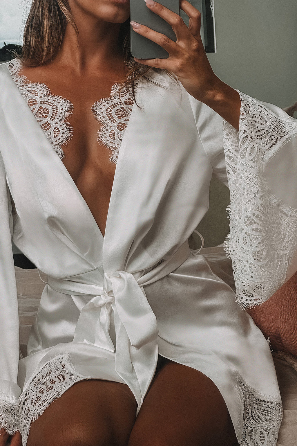 Woman sitting down in a satin bridal robe