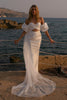 Woman in a satin wedding dress standing by the ocean_XS_