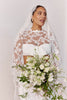 Woman in a long sleeve lace wedding dress holding a bouquet_L_