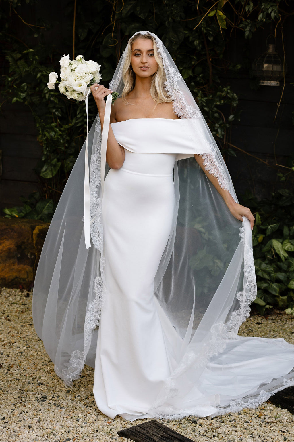 Bride wearing a mantilla veil and crepe wedding dress