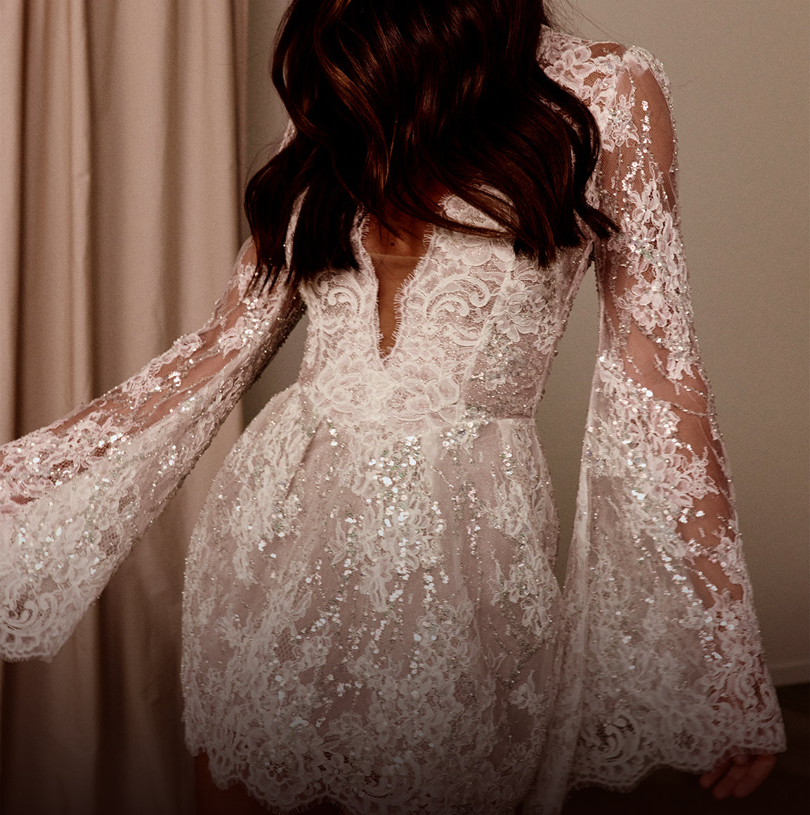 Short lace wedding dress with long sleeves.