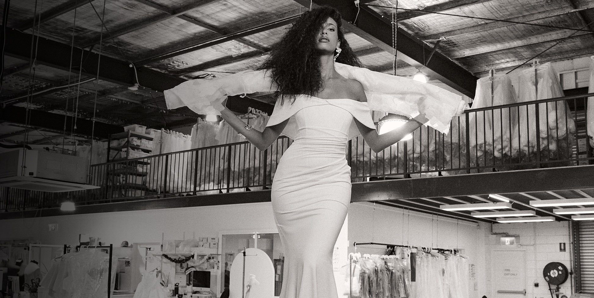 Woman wearing an off-the-shoulder wedding dress in a studio.