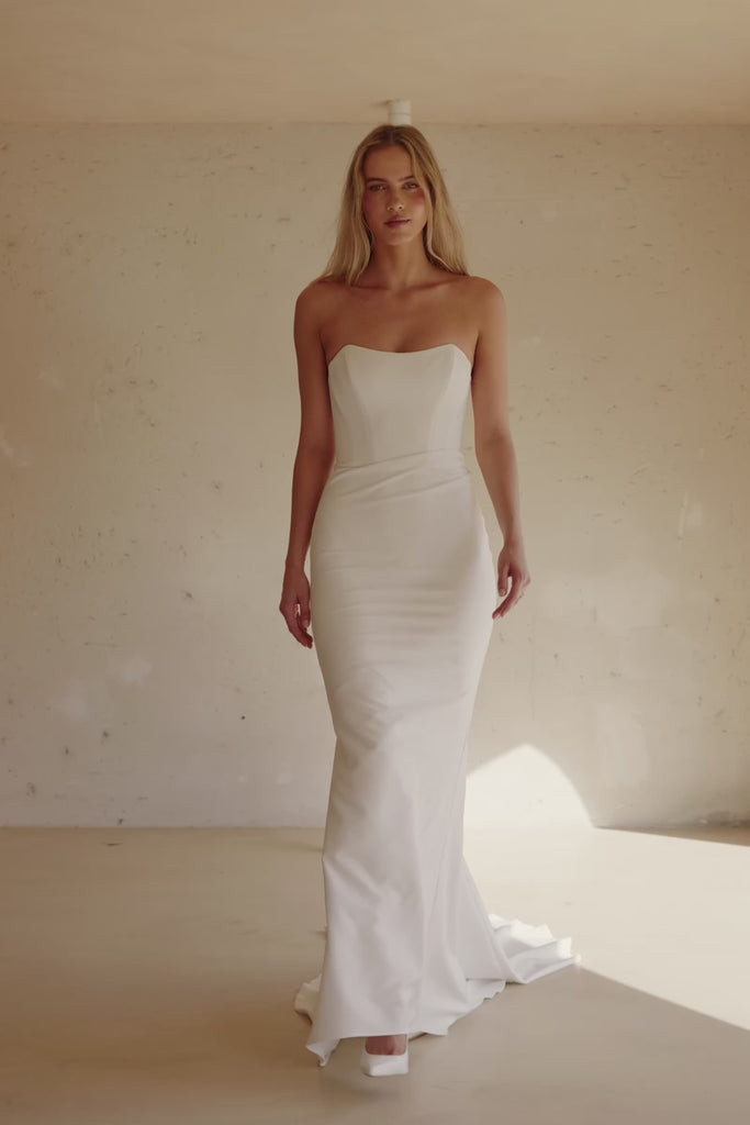Video of a woman wearing a strapless white mermaid-style gown